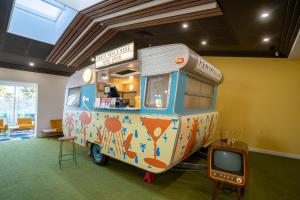 a food truck parked in a room with a tv at Peninsula Hotel Motel in Adelaide