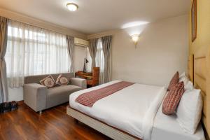 ein Schlafzimmer mit einem Bett und einem Sofa in einem Zimmer in der Unterkunft Shaligram Hotel & Spa in Pātan