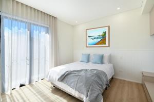 a bedroom with a bed and a large window at Nova Kiama in Kiama