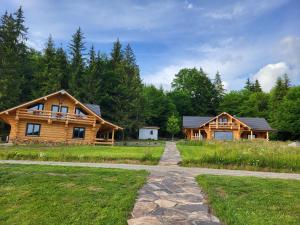 un tronco con un sentiero che lo porta a casa di Harghita Log Houses a Izvoare