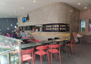 a restaurant with tables and red chairs and a bar at Grand Ion Delemen Premium Suites & Room by TOP HOME in Genting Highlands
