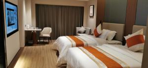 Habitación de hotel con 2 camas y mesa en Morningup Hotel, Wugang, en Wugang