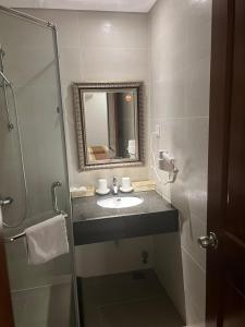 a bathroom with a sink and a mirror at Galaxy Airport Hotel in Ho Chi Minh City