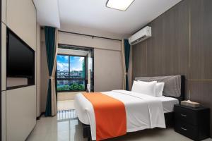 a hotel room with a bed and a window at Morninginn, Jingzhu Square in Hengyang