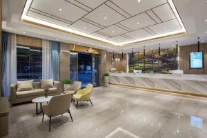 a lobby with a couch and a table and chairs at Morninginn, Radio and Television Center Xianglong Metro Station in Xingsha