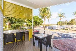 a patio with a table and chairs on a deck at Reflections Brunswick Head - Holiday Park in Brunswick Heads