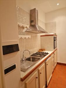 una cocina con fregadero y estufa en DOMUS SAN CARLO LUXURY, en Caserta