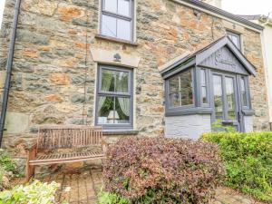 Un banco de madera situado fuera de un edificio de piedra. en Greenbanks, en Newport