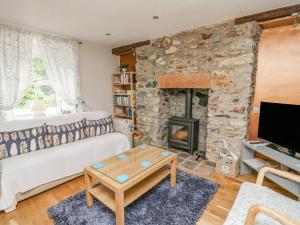 sala de estar con pared de piedra y chimenea en Greenbanks, en Newport