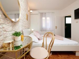 ein kleines Schlafzimmer mit einem Bett und einem Spiegel in der Unterkunft Guesthouse Ana Trogir Old Town in Trogir