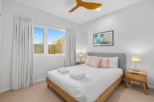 a bedroom with a large white bed and a window at Tea Trees in Woolgoolga