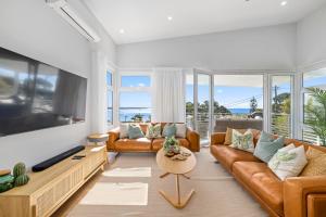 a living room with a couch and a tv at Tea Trees in Woolgoolga