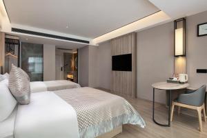 una camera con letto, tavolo e sedia di Morning Hotel, Chenzhou Anren Xintiandi Plaza a Anren