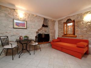 ein Wohnzimmer mit einem roten Sofa und einem Tisch in der Unterkunft Guesthouse Ana Trogir Old Town in Trogir