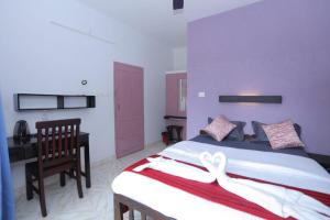 a bedroom with a bed with a ribbon on it at Sky Frame Beach Resort in Varkala