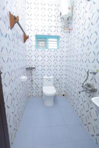 a bathroom with a toilet and a sink at Sky Frame Beach Resort in Varkala