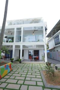 a white building with a patio in front of it at Sky Frame Beach Resort in Varkala