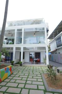 un edificio blanco con un patio enfrente en Sky Frame Beach Resort, en Varkala