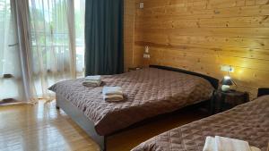 a bedroom with two beds and a wooden wall at MiMi in Tsandrypsh