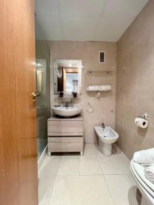 bagno con lavandino, servizi igienici e specchio di Campello Apartamento junto a la playa 2-4 pax Inmobiliaria Leo a El Campello