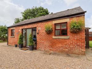 a small brick house with potted plants on it at The Stables in Preston