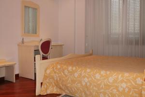 a bedroom with a bed and a desk and a chair at Park Hotel Gianfranco in Roccella Ionica