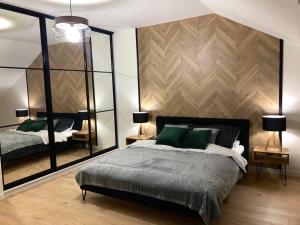 a bedroom with a large bed with green pillows at Apartamenty Ewa in Karpacz