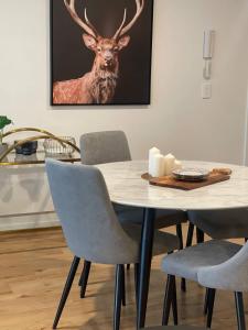 mesa de comedor y sillas con una foto de ciervo en la pared en Cozy 3BR Apartment Walking Distance to GOMA, en Brisbane