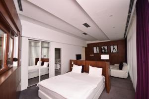 a bedroom with a large white bed and a couch at Sesto Senso in Trebinje