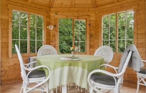 comedor con mesa, sillas y ventanas en Awesome Home In Stokkemarke With Kitchen en Stokkemarke