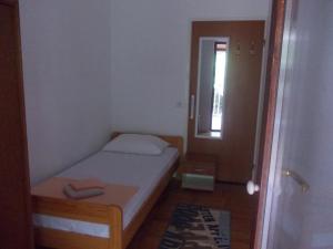 a small bedroom with a small bed and a mirror at Apartmani Crkvina in Gradac