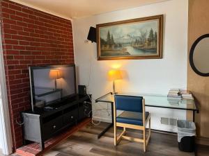 a room with a desk with a television and a chair at Affordable Private Rooms with Shared Bath Kitchen near SFO (SA) in Daly City