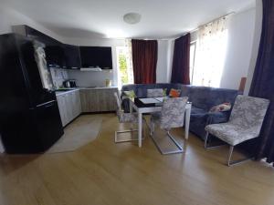uma sala de estar com um sofá, uma mesa e cadeiras em 2 Rooms Apartament with sea views em Sveti Vlas