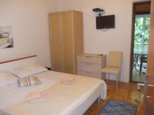 a bedroom with a bed and a cabinet and a chair at Apartmani Crkvina in Gradac