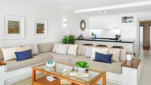 een woonkamer met een bank en een tafel bij Belle Escapes presents 14 Alamanda Resort Where Pure Luxury meets the Coral Sea in Palm Cove