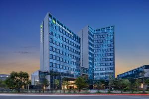 een hoog gebouw met veel ramen bij Wyndham Garden Shenzhen Longhua in Shenzhen