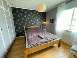 a bedroom with a bed with a purple comforter at Centralt belägen villa i Öjebyn, Piteå in Piteå