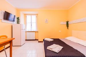 Kleines Zimmer mit einem Bett und einem Kühlschrank. in der Unterkunft La Santa Maria in Cuneo