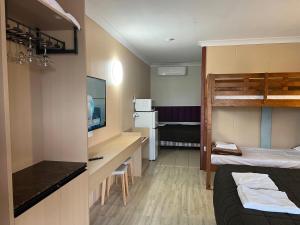 a room with a bed and a desk and a bunk bed at Central Jetty Motel in The Entrance