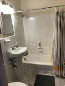 a bathroom with a sink and a tub and a toilet at Walk2Metro's,DCGem,Private,Wifi, FreeParking in Arlington