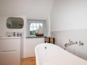 a bathroom with a white tub and a sink at Downrow Barn in Tintagel