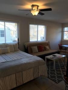 a bedroom with two beds and a couch and a ceiling fan at Walk2Metro's,DCGem,Private,Wifi, FreeParking in Arlington