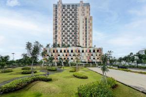 un edificio alto con un parque delante de él en RedLiving Apartemen Sayana - Premium Property, en Tambun-lobangbuaja