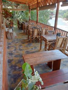 an empty restaurant with wooden tables and chairs at Sumatra Jungle Trek In & Orangutan Trips in Bukit Lawang