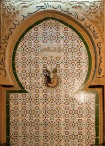 a mosaic wall with a bee on it at Hotel Riad Fantasia in Marrakech