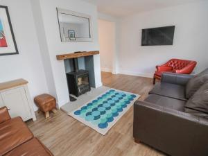 a living room with a couch and a fireplace at 3 St Cuthberts Garth in Bamburgh