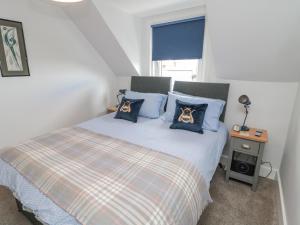 a bedroom with a bed with two dogs pillows on it at 3 St Cuthberts Garth in Bamburgh