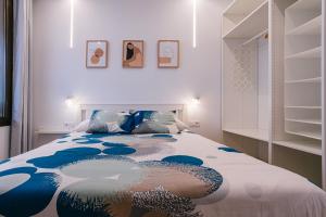 sypialnia z łóżkiem z niebiesko-białym kocem w obiekcie 1linea Canteras w mieście Las Palmas de Gran Canaria