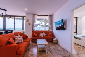a living room with a couch and a table at Canteras 1º Linea de Playa in Las Palmas de Gran Canaria