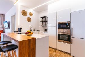a kitchen with white appliances and a wooden counter top at 1linea Canteras in Las Palmas de Gran Canaria